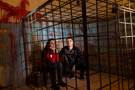 夫妇的害怕万圣节受害者禁锢在金属笼无线照片