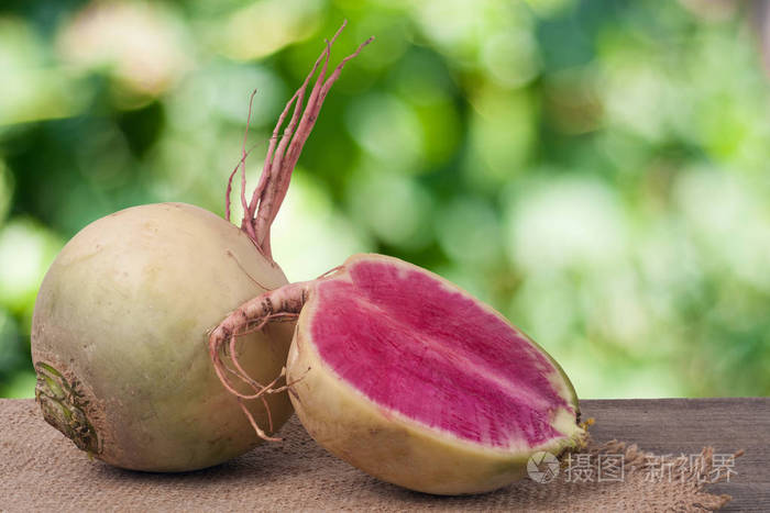 一整片西瓜萝卜与模糊的花园背景木制的桌子上照片-正版商用图片1qup5