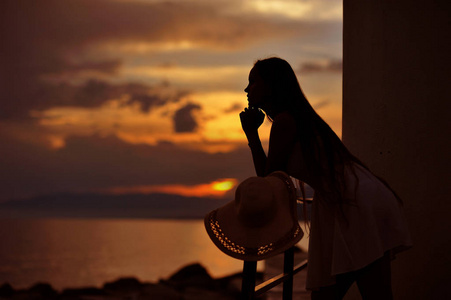 年轻女子在傍晚日落时的剪影照片