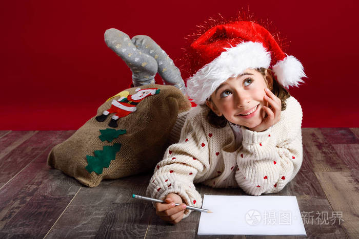 可爱的小女孩，穿上圣诞老人的帽子圣诞老人写信
