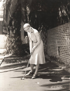 在字段上打高尔夫球的女人图片