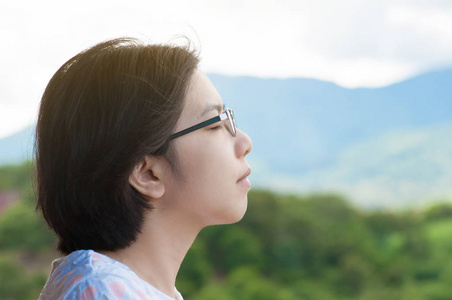亚洲女人站在阳台上,呼吸新鲜空气照片