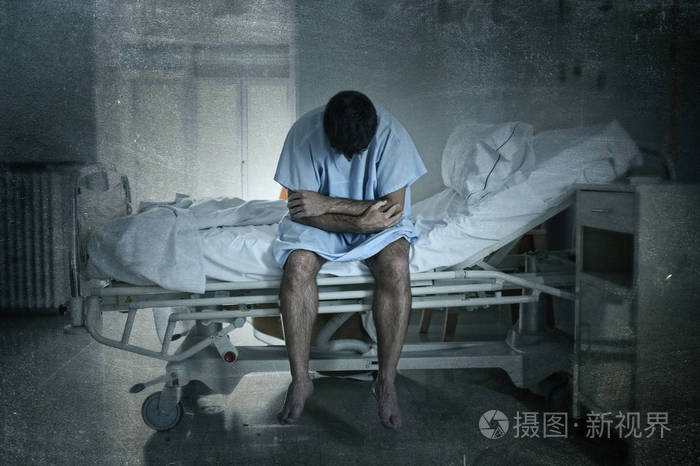 绝望的男人坐在医院的床上独自伤心和受灾患上抑郁症在诊所哭