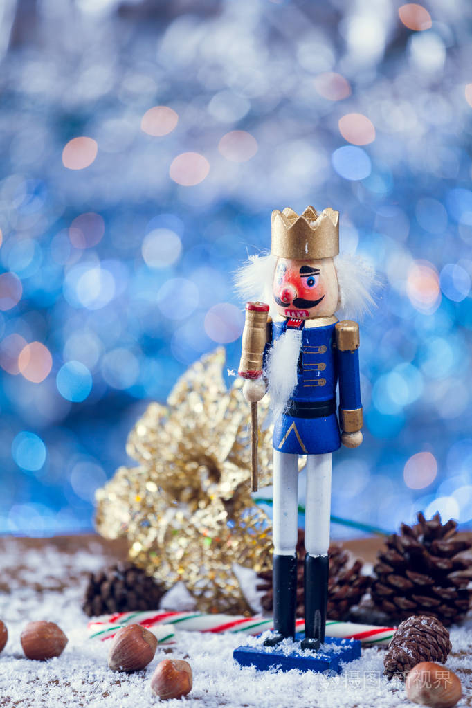 站在圣诞节背景前的国王胡桃夹子铜像