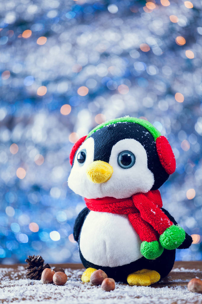 微笑在白雪皑皑的木材上的可爱快乐企鹅圣诞玩具