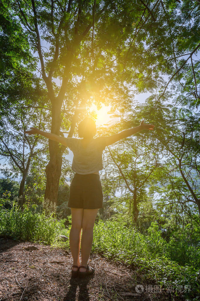 年轻女子举起双臂庆祝自由积极的人类情感感受生命感知成功平和的心态