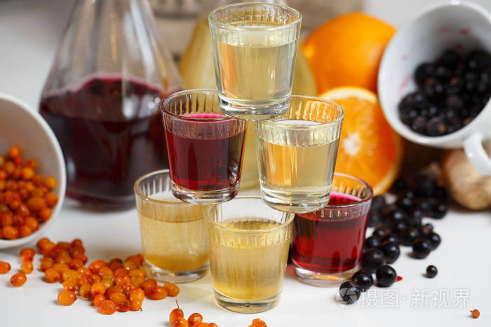 穗醋栗酒在木制的桌子上一瓶.由许多品种浆果制成的甜醇