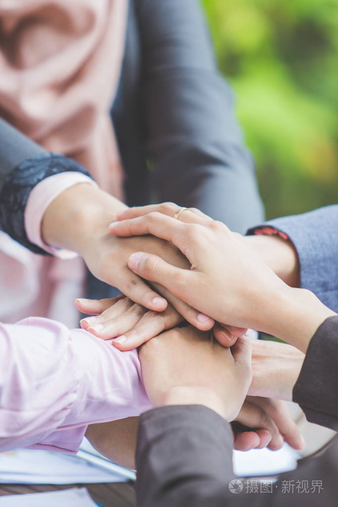 四个年轻的商业人士在一起把他们的手