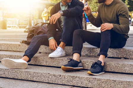 和说话穿着休闲街头风格的衣服和运动鞋的台阶上坐着的生活照片照片