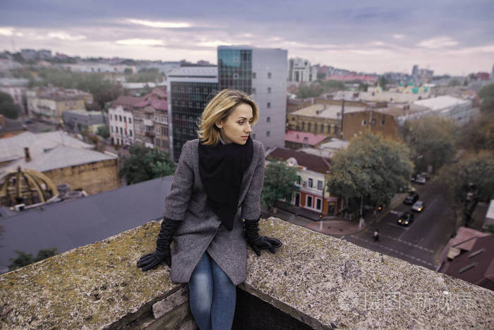 照片 年轻有魅力的女人带着好心情享受而站在屋顶的建筑,美丽的城市