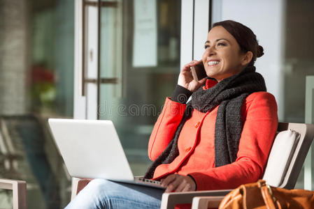 有魅力的女人穿着红色外套打电话