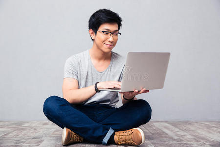 快乐的亚洲男人用笔记本电脑
