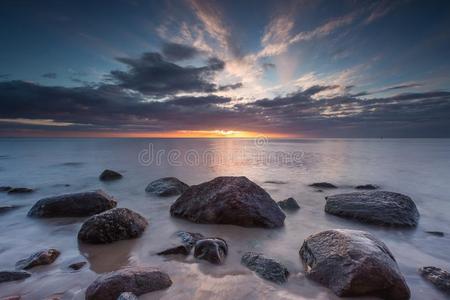 日出或日落时美丽的岩石海岸。