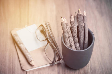 彩色铅笔由树枝和眼镜制成，并在木头上写上笔记