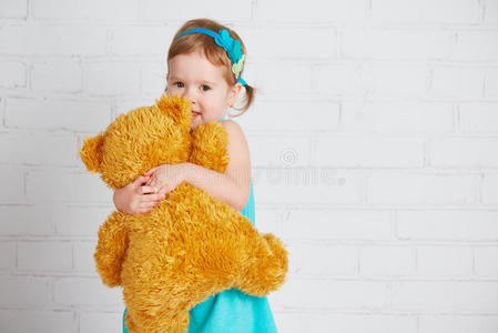抱着心爱的泰迪熊的女婴