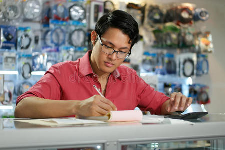 在电脑商店工作的中国人检查账单和税收