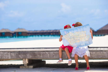 可爱的小女孩带着海滩上的岛屿地图