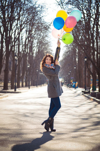 美丽的女人在春天的公园里有五颜六色的气球