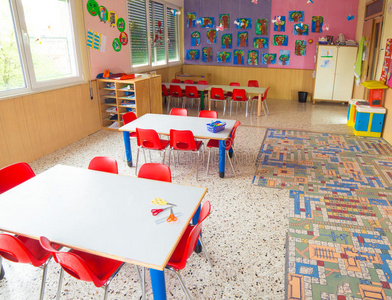 有桌子和红色小椅子的幼儿园教室
