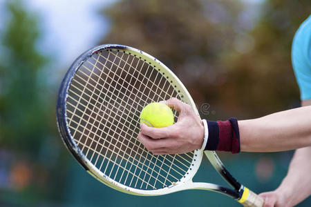 职业男子网球运动员手的特写,手握拍和网球接触.照片