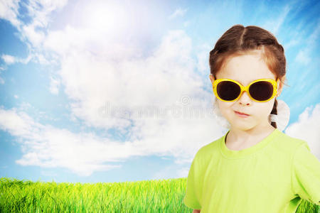 可爱的小女孩戴着太阳镜对抗自然