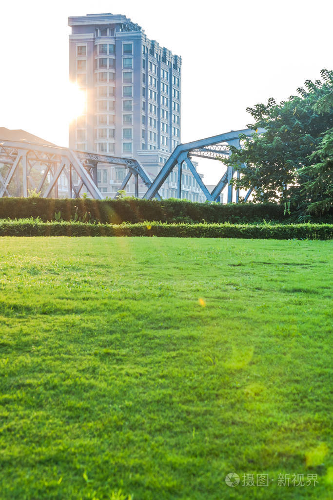 空的绿色领域与城市景观的背景