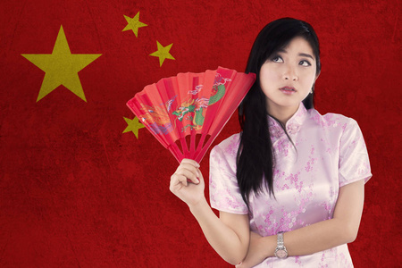 中国女人与旗袍礼服和风扇图片