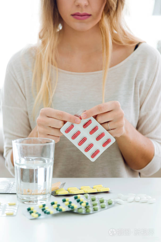 抑郁症的年轻妇女在家吃药照片-正版商用图片1r4uaw-摄图新视界