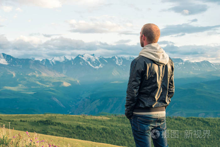 旅行者呆在一座山上,眺望远方.山脉