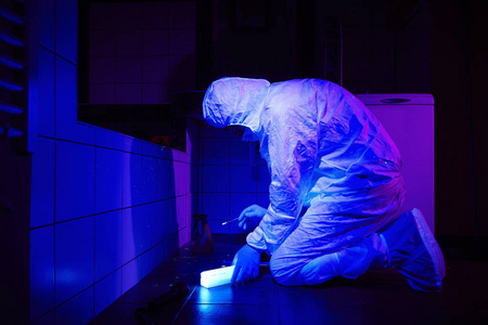 犯罪学家收集 dna 上的犯罪在紫外光照射下的地方照片