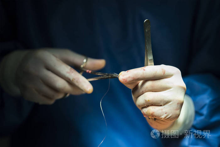 外科医生拿着针和线