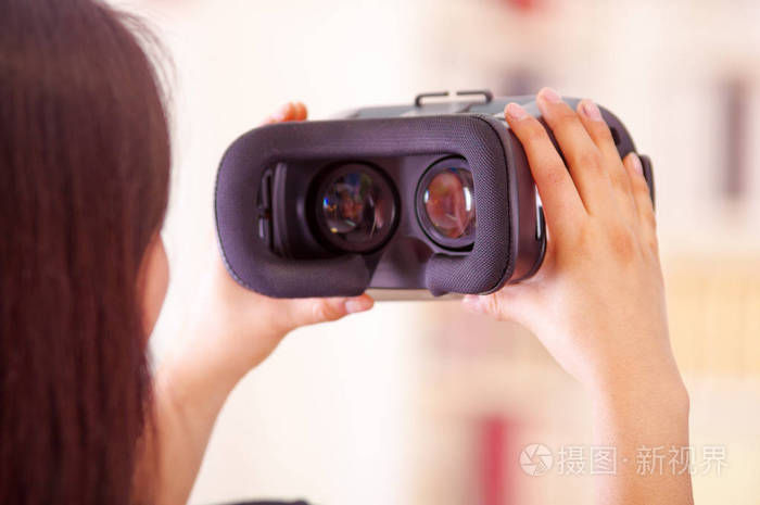 年轻的黑发女人举起虚拟现实的护目镜展示给相机，vr 概念