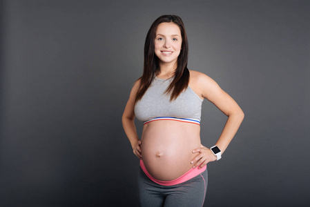 快乐怀孕运动快乐怀孕女运动员腰部的手照片