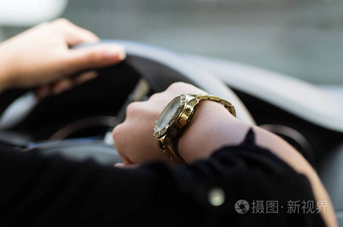 女人手抓着方向盘另一只胳膊炫耀手表女司机概念车内特写