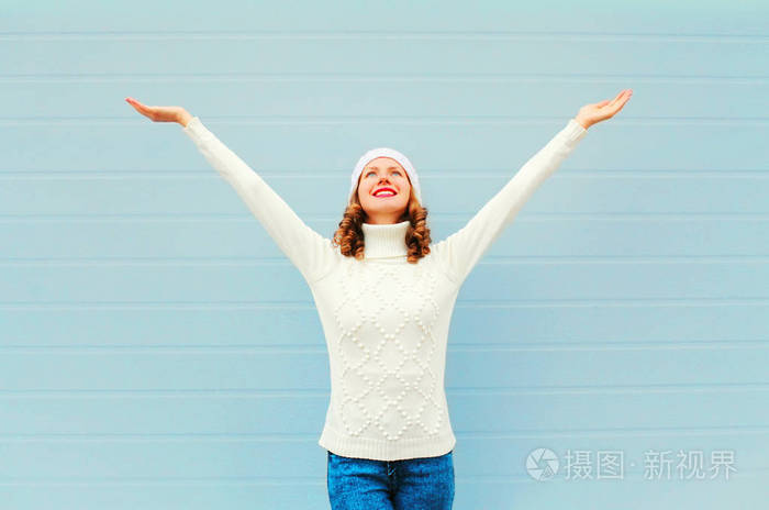 幸福微笑的女人开心升高在蓝色酒泉举起手来