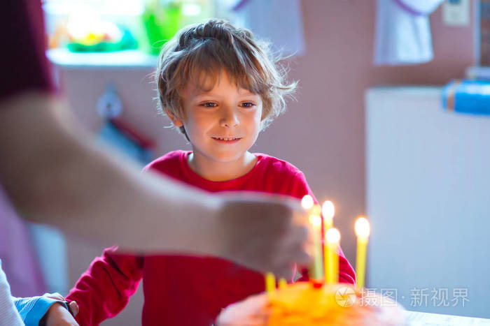 小小孩男孩庆祝他的生日和吹蜡烛蛋糕上
