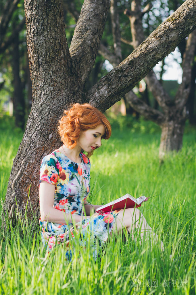春天的花园里读书的美丽女人