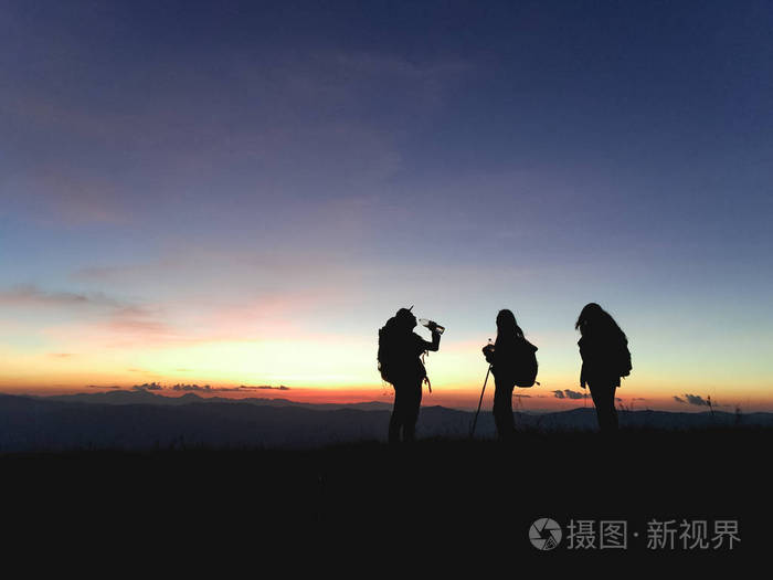享受着从山顶的日落景色的背包组徒步旅行者人的剪影旅游概念老式过滤