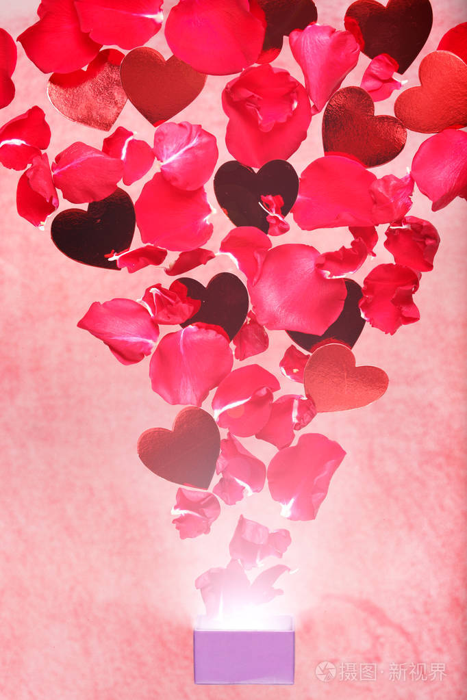 玫瑰花瓣和心从礼盒里飞出来有质感的粉红色背景情人节背景浪漫的概念