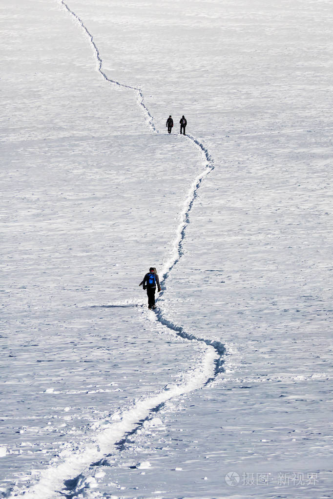 在雪地里的轨道上行走的人