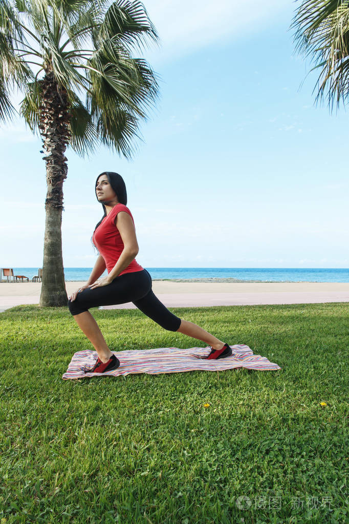 女人锻炼体育锻炼在户外在海滩上