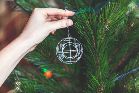 手挂在圣诞树优雅的铁丝球图片