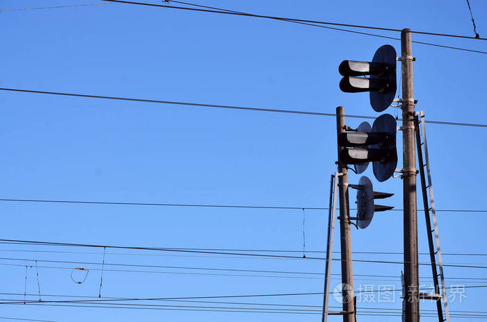 铁路交通灯对蓝天接触线带有交通信号灯的中性蓝天背景上的高速铁路