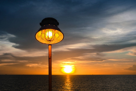 晚上和海上日落温暖的灯的照明和照明的日落在海上照片