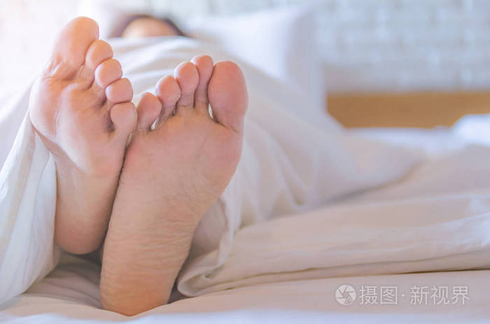 关闭了妇女睡在床上的女人的脚