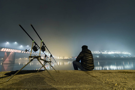 渔夫在雾气朦胧的夜晚照片