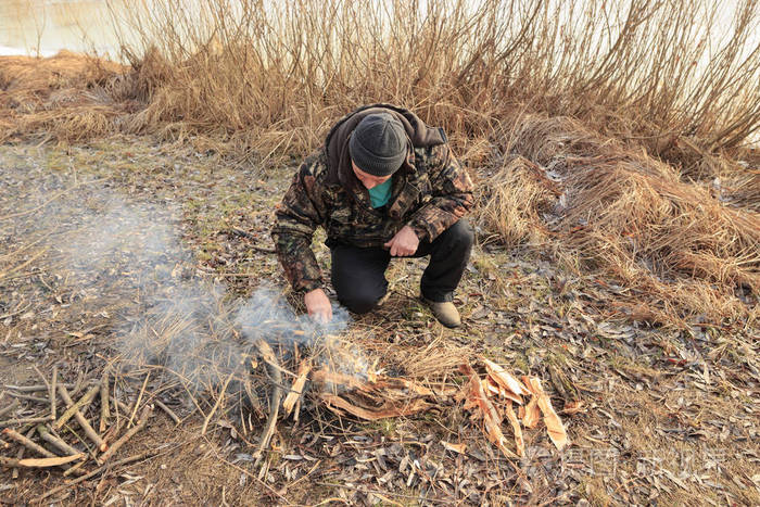 一个人在户外的深秋中的火