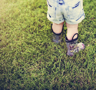 小孩子在绿色草地上行走图片