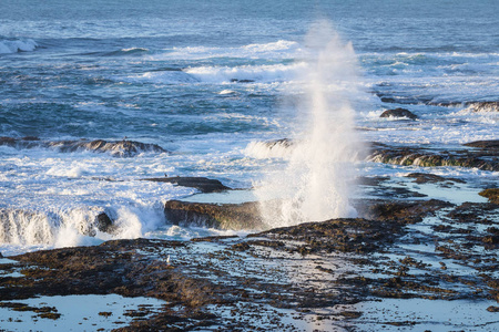 在岩浆岩绝壁上的海浪图片