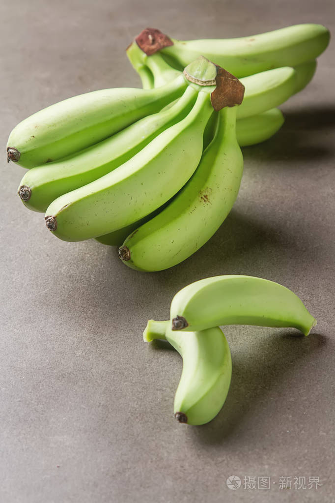 一堆成熟的绿色香蕉灰色背景